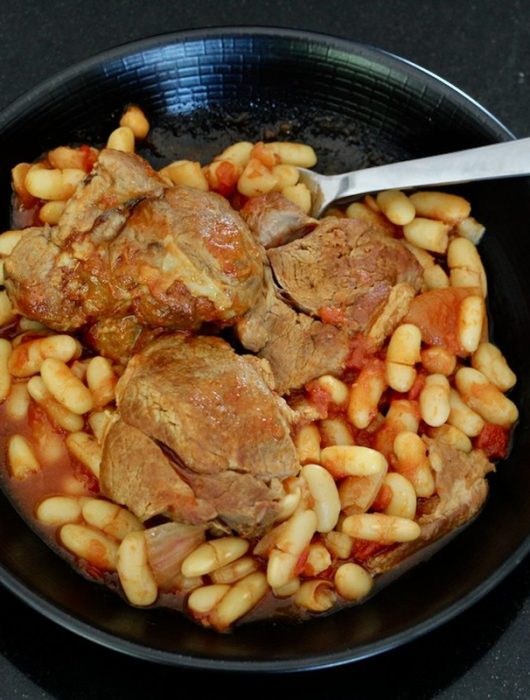 Ragoût d'agneau aux haricots blancs dans un bol noir, vue de dessus