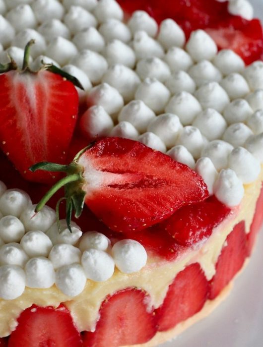 Fraisier gastronomique avec fraises fraîches et crème chantilly élégamment disposées