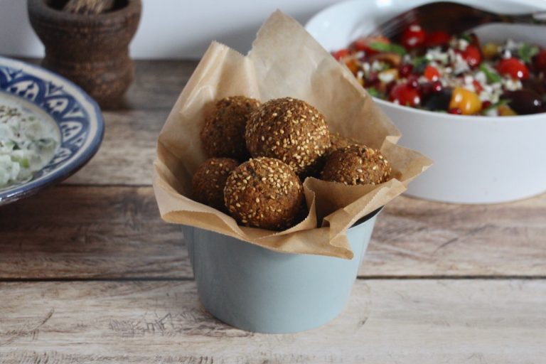 Falafels dorés aux graines de sésame dans un bol en papier kraft