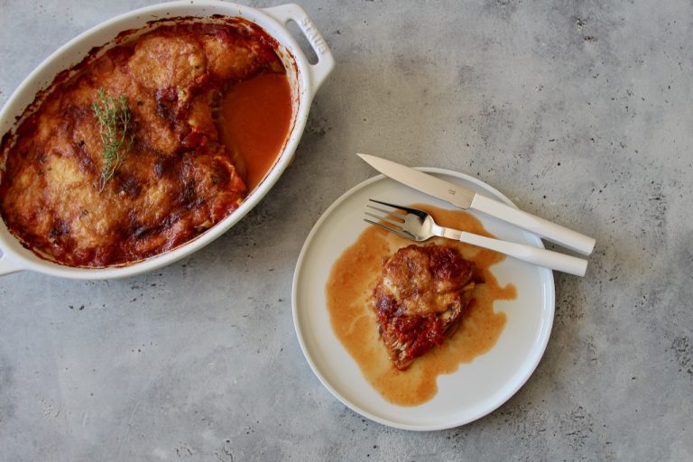Gratin aubergine doré avec croûte croustillante, servi sur assiette blanche