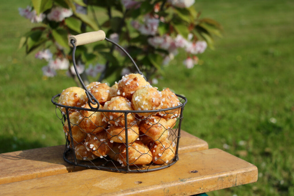 Chouquettes dorées parsemées de sucre perlé dans un panier sur une table en bois, parfait exemple d'une recette pâte à choux professionnel