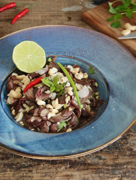 Salade thai boeuf garnie de noix de cajou et rondelles d'oignon rouge