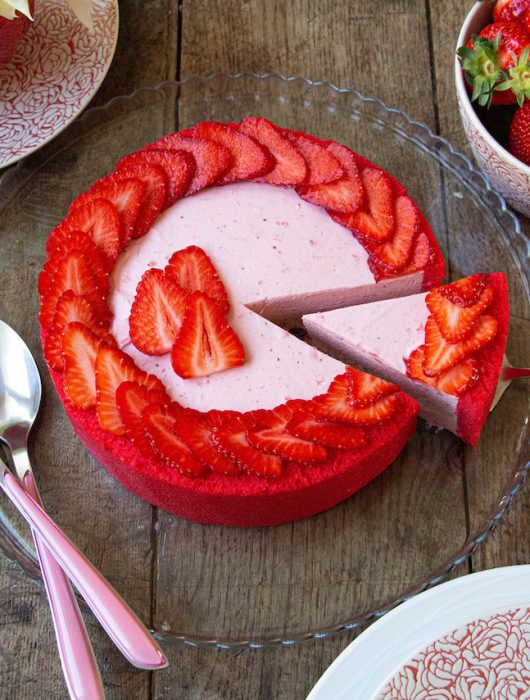 Bavarois fraise garni de tranches de fraises sur assiette en verre