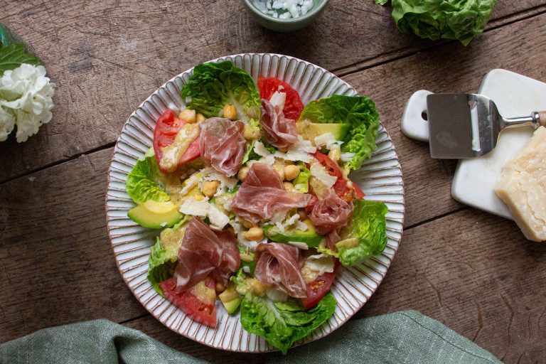 Assiette de salade de pois chiche colorée avec coppa, avocat et tomates fraîches