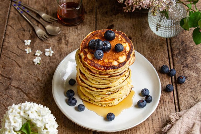 Pile de pancakes au yaourt garnis de myrtilles et de sirop doré