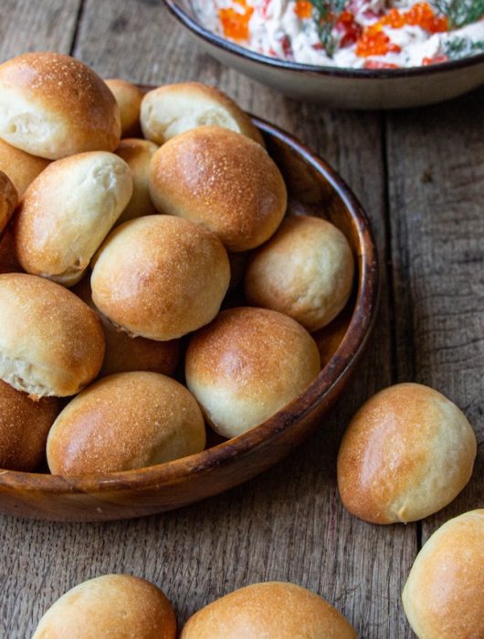 Petits pains dorés et moelleux, navette pain, dans un bol en bois rustique