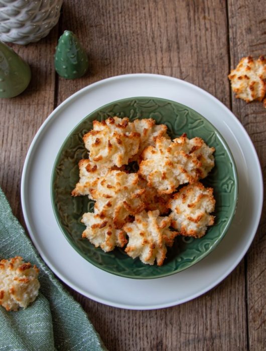 Rochers coco dorés dans un bol vert sur une table en bois rustique