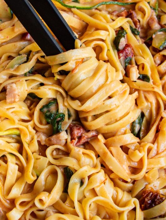 Tagliatelles crémeuses avec lardons et courgettes, one pot courgette, en gros plan vibrant