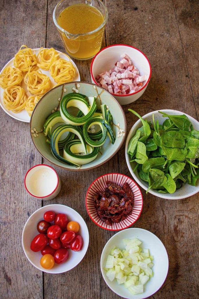 Ingrédients variés pour one pot courgette sur table en bois rustique