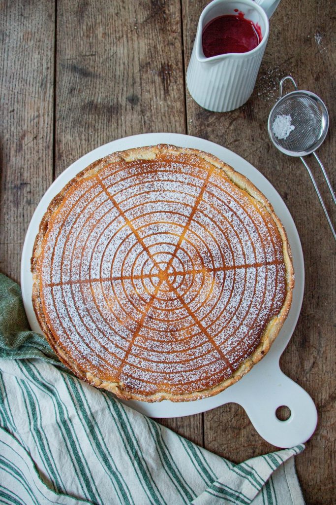 Tarte au fromage blanc saupoudrée de sucre glace sur planche en bois rustique