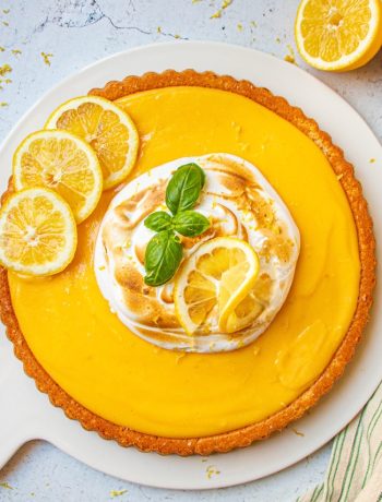 Gâteau au citron meringué avec tranches de citron et feuille de basilic, vue de dessus