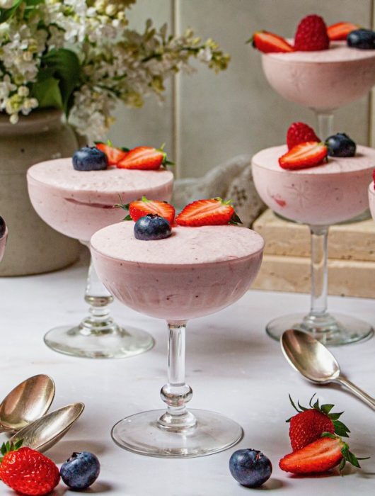 Coupes élégantes de mousse de fraise garnies de fruits frais et baies