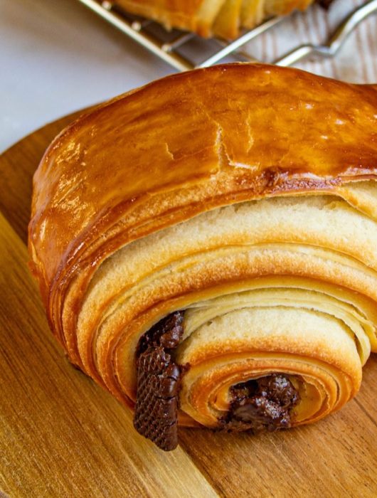 Gros plan sur un pain au chocolat doré, aux couches feuilletées et chocolat fondant