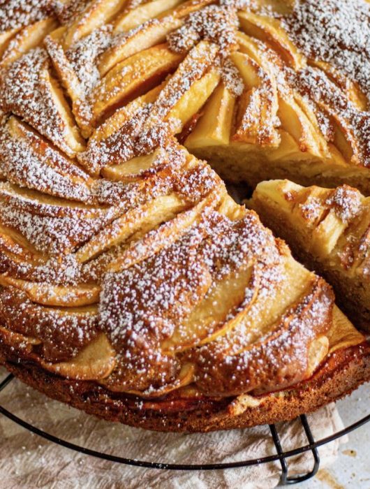 Gâteau mascarpone aux pommes dorées, saupoudré de sucre glace sur grille de refroidissement