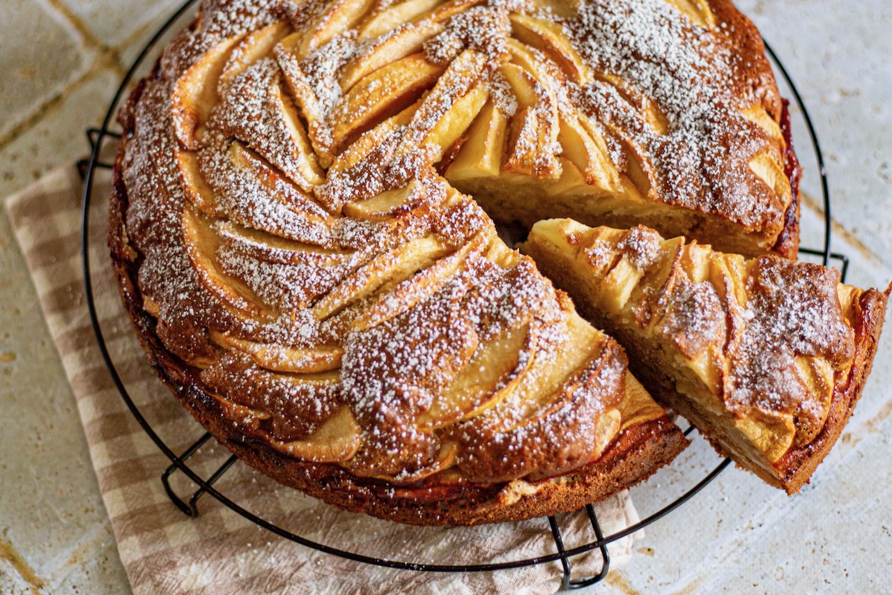 gateau aux pommes mascarpone en visuel plein de haut avec sucre glace et part découpée