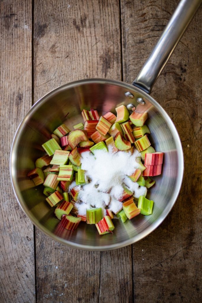 Morceaux de rhubarbe et sucre dans une casserole pour tarte rhubarbe fraise