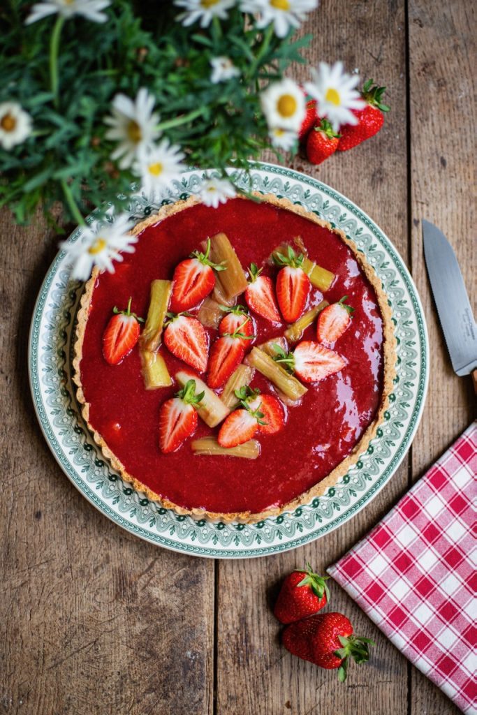 Tarte rhubarbe fraise vue de dessus, fraises fraîches et décoration florale